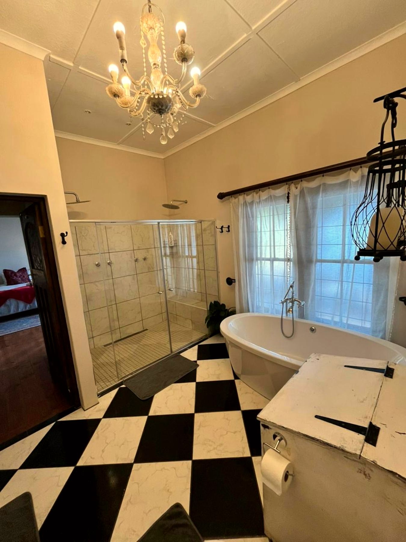 The bathroom with chandelier and freestanding bath
